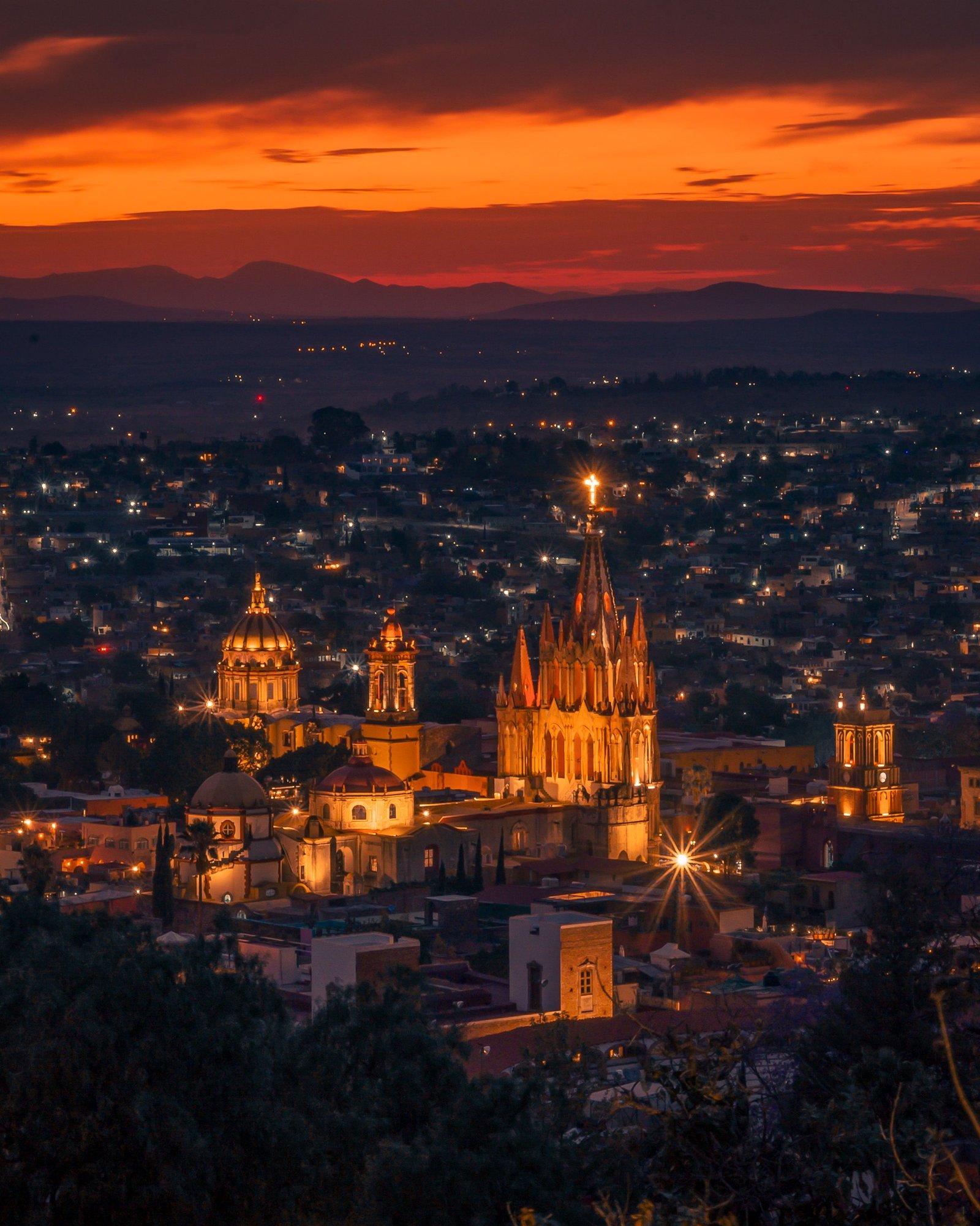 Vista panorámica de San Miguel de Allende al atardecer, con La Parroquia iluminada.